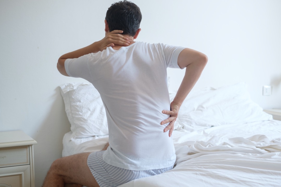 マットレスで寝ると腰と首が痛い男性